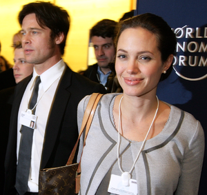 Picture of a smiling woman, with other men wearing suits.